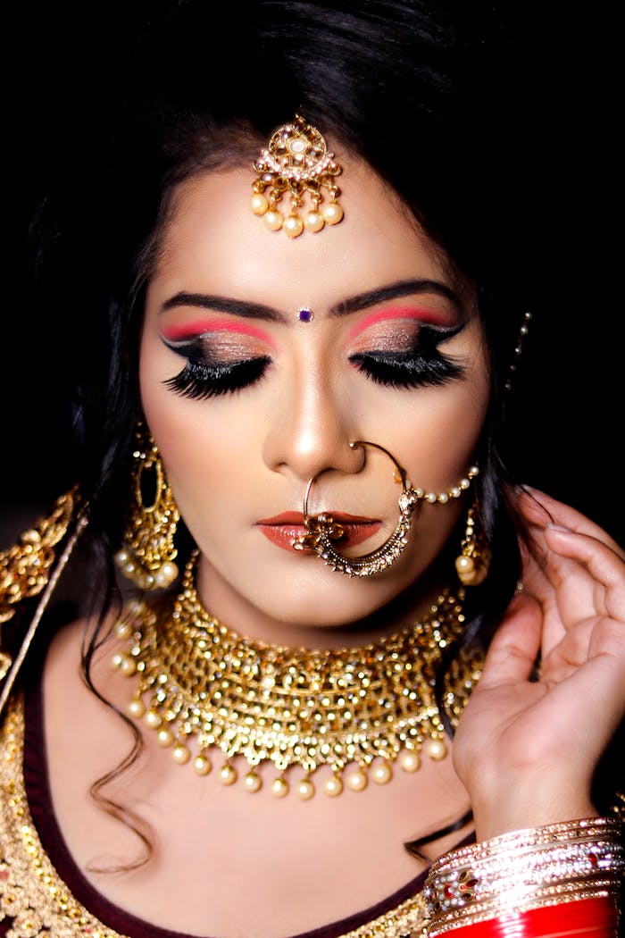 Close-up portrait of a woman adorned in traditional jewelry and makeup, conveying elegance and style.