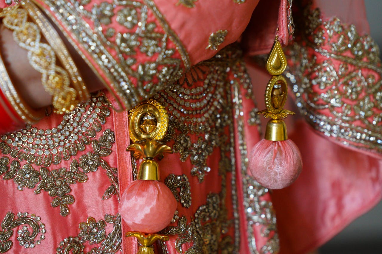 home-hero Close-up of detailed embroidery and embellishments on pink traditional attire.
